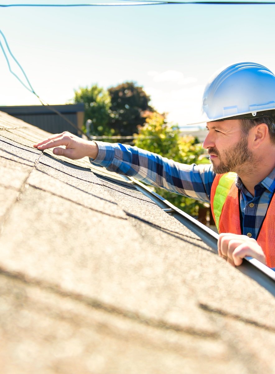 man examining roof